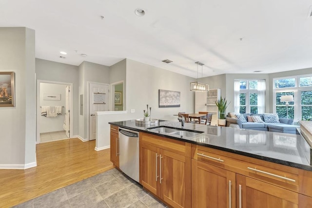 1200 Grand St Unit 220, Hoboken, NJ 07030 - kitchen with stainless steel dishwasher, brown cabinetry, dark stone countertops, pendant lighting, and open floor plan