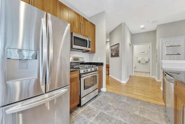 1200 Grand St Unit 220, Hoboken, NJ 07030 - kitchen with stainless steel appliances, brown cabinets, dark countertops, light tile patterned floors, and recessed lighting