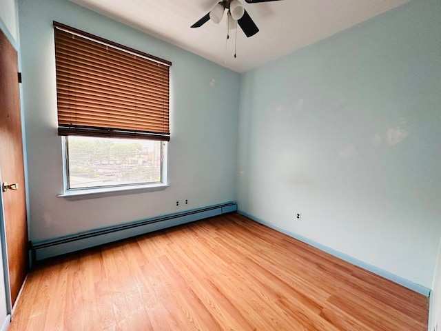 spare room with hardwood / wood-style floors, ceiling fan, and a baseboard radiator