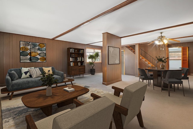 1508 77th St, North Bergen, NJ 07047 - living area with wood walls, stairway, healthy amount of natural light, light carpet, and ceiling fan