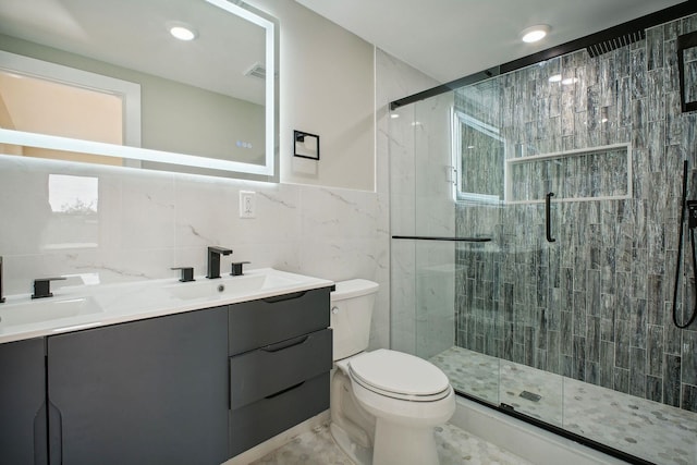 bathroom with tile walls, an enclosed shower, vanity, and toilet