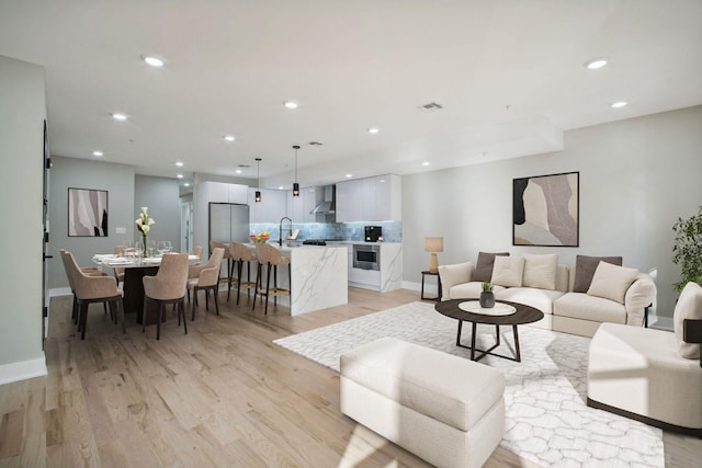 living room featuring light wood-type flooring and sink