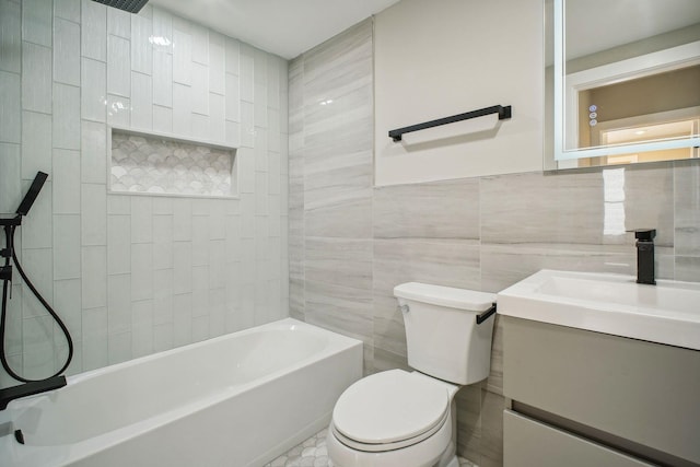 full bathroom featuring toilet, tile patterned flooring, tile walls, tiled shower / bath combo, and vanity