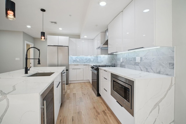 kitchen with appliances with stainless steel finishes, pendant lighting, decorative backsplash, white cabinets, and sink