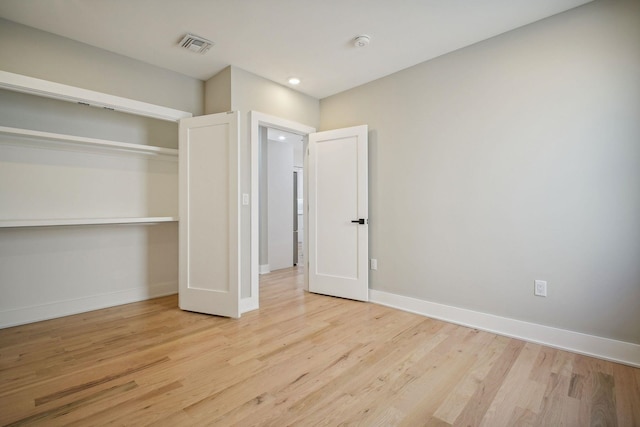 unfurnished bedroom featuring light wood-type flooring and a closet