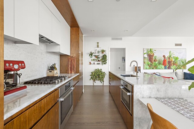 75 Park Ln S Unit 706, Jersey City, NJ 07310 - kitchen with visible vents, appliances with stainless steel finishes, a sink, under cabinet range hood, and dark wood-type flooring