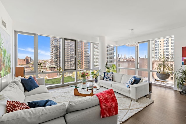 75 Park Ln S Unit 706, Jersey City, NJ 07310 - living area with visible vents, a city view, wood finished floors, and a chandelier