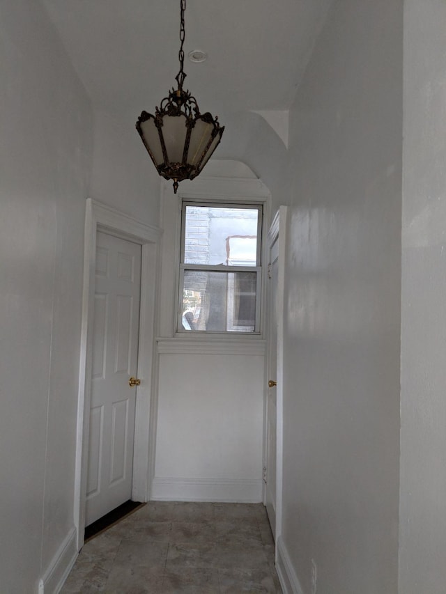 corridor with an inviting chandelier