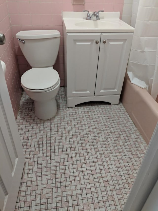 full bathroom featuring toilet, tile patterned flooring, shower / bath combo with shower curtain, and vanity