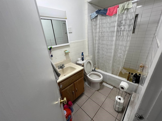 full bathroom with shower / bath combo with shower curtain, vanity, tile patterned floors, toilet, and tile walls