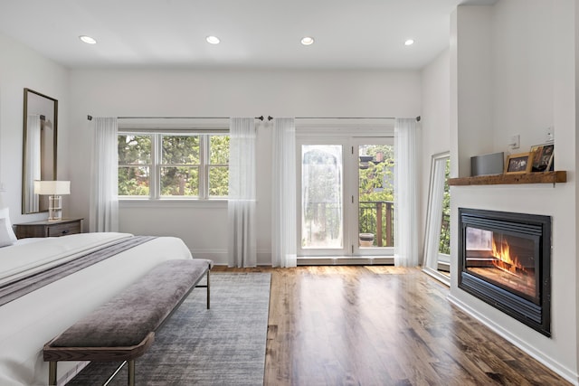 297 Montgomery St Unit 2, Jersey City, NJ 07302 - bedroom featuring multiple windows, a glass covered fireplace, wood finished floors, access to outside, and recessed lighting