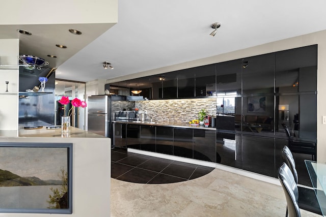 kitchen featuring dark tile patterned flooring, stainless steel fridge, and backsplash