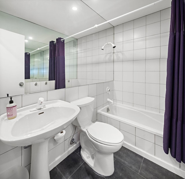 bathroom with toilet, tile patterned flooring, shower / tub combo with curtain, and tile walls