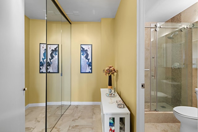 bathroom with toilet and a shower with door