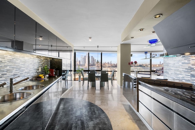 kitchen featuring tasteful backsplash, sink, pendant lighting, and a wall of windows