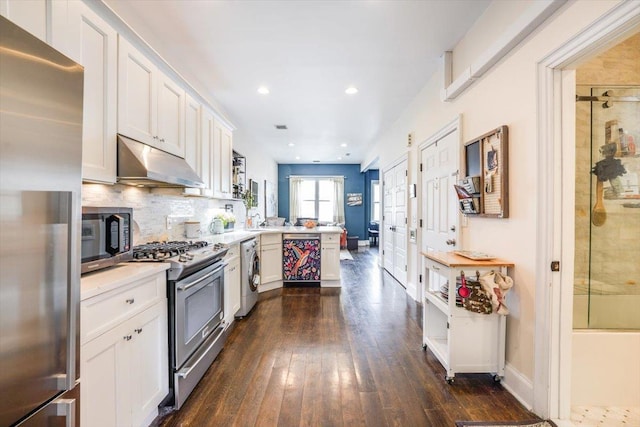 351 5th St Unit 3, Jersey City, NJ 07302 - kitchen featuring stainless steel appliances, under cabinet range hood, a peninsula, washer / clothes dryer, and dark wood-style flooring