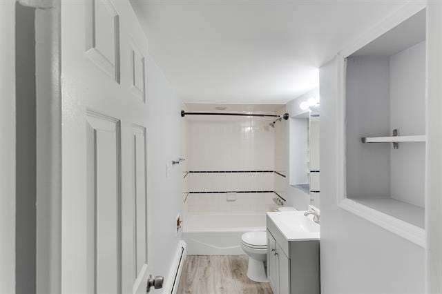 1406 8th St Unit 2, North Bergen, NJ 07047 - bathroom with vanity, a baseboard heating unit, toilet, wood finished floors, and bathing tub / shower combination
