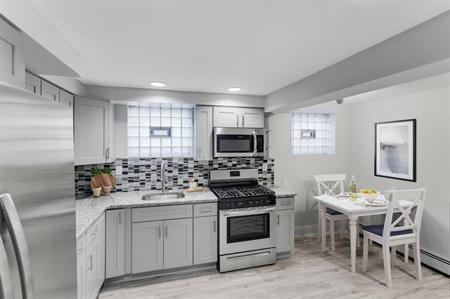 1406 8th St Unit 2, North Bergen, NJ 07047 - kitchen with stainless steel appliances, a sink, gray cabinetry, backsplash, and recessed lighting