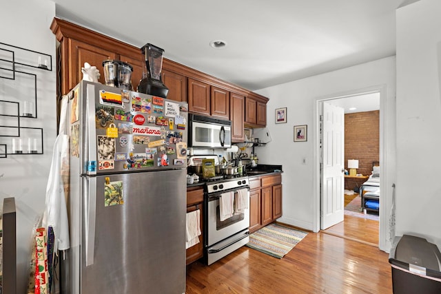 kitchen with hardwood / wood-style floors and appliances with stainless steel finishes