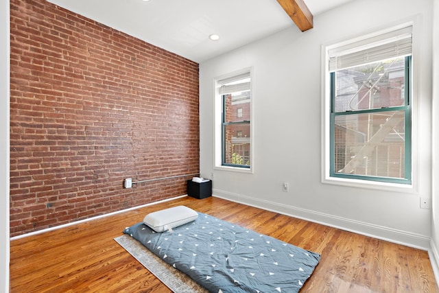 interior space with wood-type flooring and brick wall