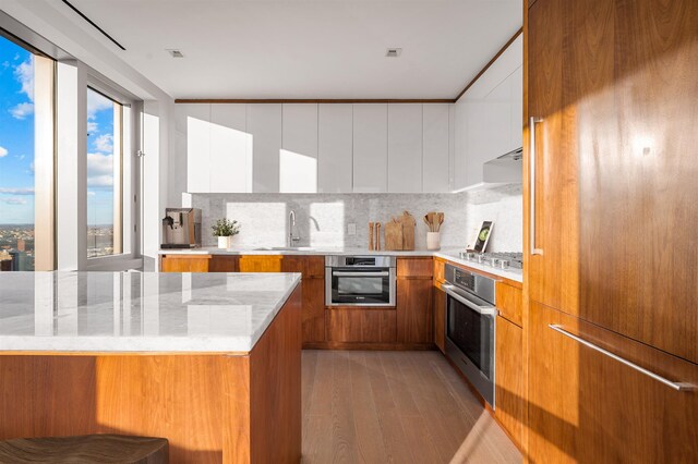 75 Park Ln S Unit 1912, Jersey City, NJ 07310 - kitchen featuring oven, modern cabinets, and brown cabinets