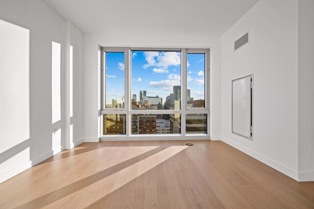 75 Park Ln S Unit 1912, Jersey City, NJ 07310 - spare room with wood finished floors, baseboards, and a skyline view