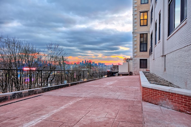 patio terrace at dusk with a city view and fence