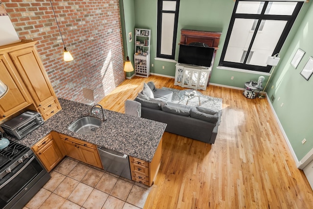 living area with a toaster, light wood-style floors, and baseboards