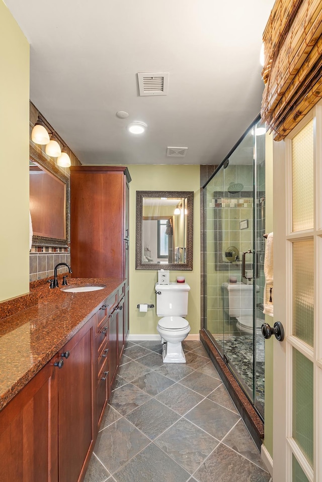 full bath with vanity, baseboards, visible vents, a stall shower, and toilet