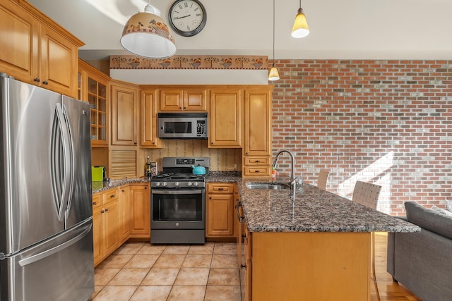 kitchen with a sink, stainless steel appliances, a peninsula, light tile patterned floors, and glass insert cabinets