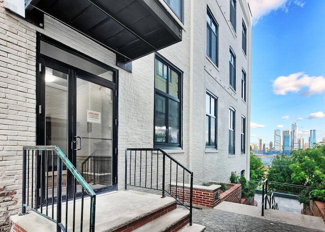 doorway to property featuring a view of city and brick siding