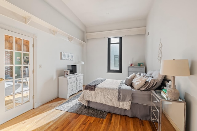 bedroom featuring access to outside and wood finished floors