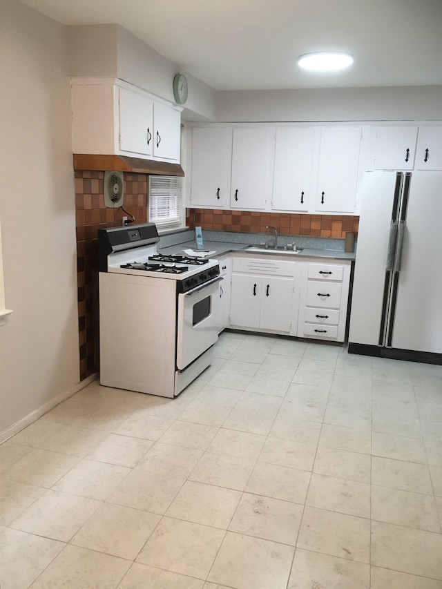 kitchen featuring visible vents, backsplash, white cabinets, a sink, and white appliances