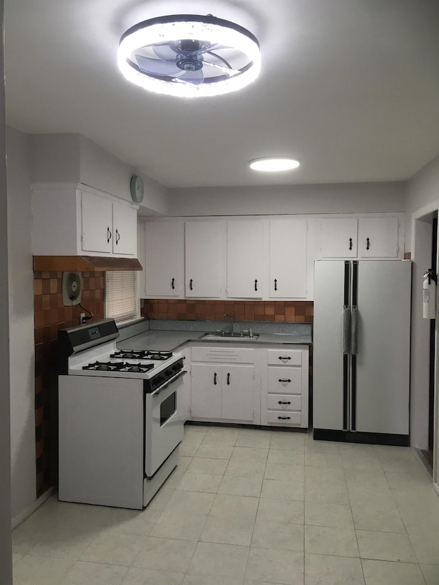 kitchen featuring white appliances, white cabinetry, and decorative backsplash