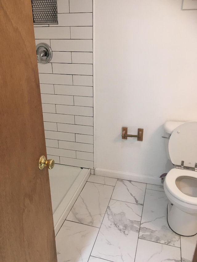 bathroom featuring marble finish floor, baseboards, a shower stall, and toilet