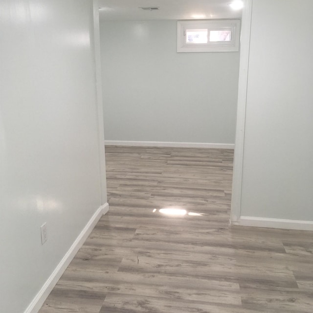 below grade area featuring wood finished floors, visible vents, and baseboards