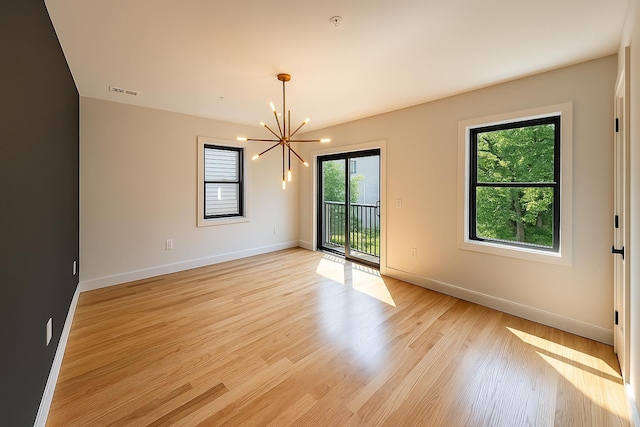 141 Sherman Ave Unit 2, Jersey City, NJ 07307 - spare room featuring a chandelier, healthy amount of natural light, and light wood-style flooring