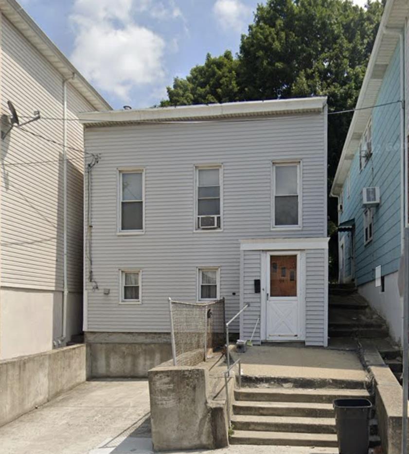 rear view of property featuring an AC wall unit