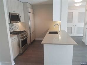 1200 Avenue At Port Imperial Unit 519, Weehawken, NJ 07086 - kitchen with stainless steel appliances, light countertops, a peninsula, and decorative backsplash