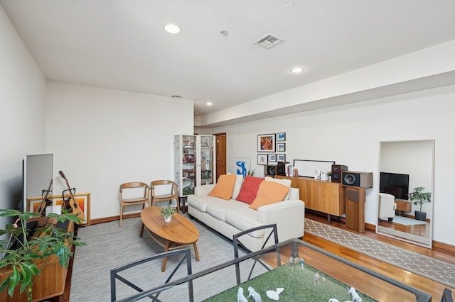 living area with recessed lighting, baseboards, visible vents, and wood finished floors