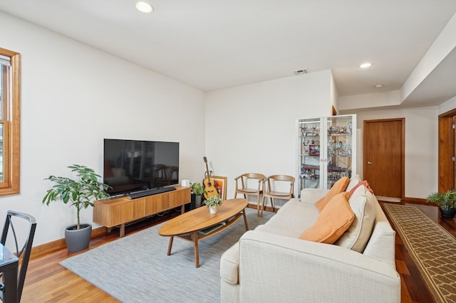 living room with baseboards, recessed lighting, and wood finished floors