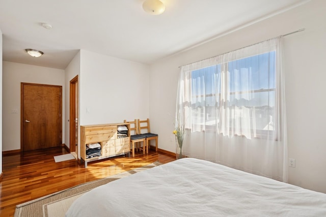 bedroom featuring baseboards and wood finished floors