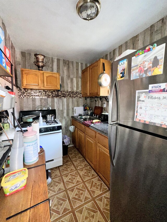552 38th St Unit 3, Union City, NJ 07087 - kitchen featuring freestanding refrigerator, white range with gas stovetop, brown cabinets, and light tile patterned floors
