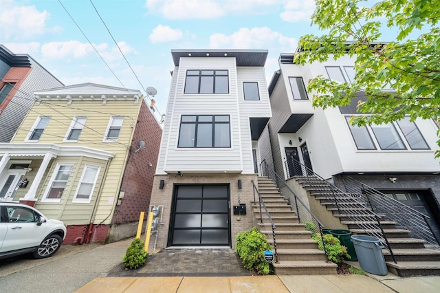 109 Poplar St Unit 1, Jersey City, NJ 07307 - view of front of property featuring an attached garage, stairway, brick siding, and driveway