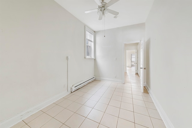 tiled empty room featuring baseboard heating and ceiling fan