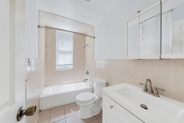 full bathroom with toilet, tile patterned floors, tile walls, tiled shower / bath, and vanity