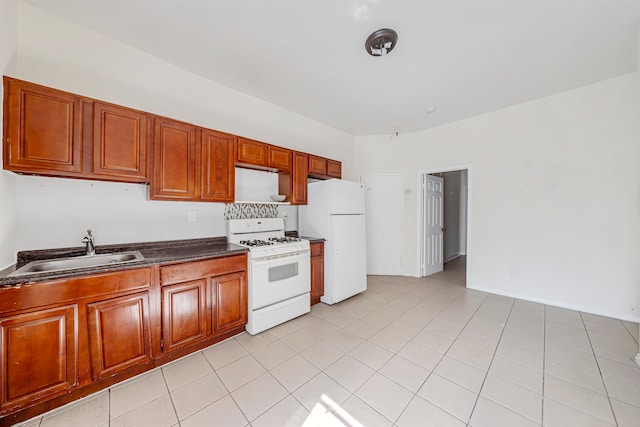 kitchen with light tile patterned floors, white appliances, and sink