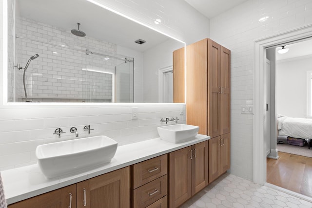 1023 Willow Ave Unit A, Hoboken, NJ 07030 - ensuite bathroom featuring double vanity, a shower stall, tile walls, and decorative backsplash