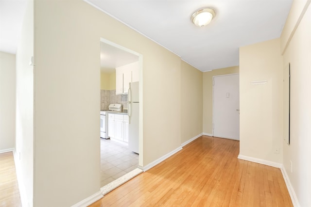 empty room featuring light wood finished floors and baseboards
