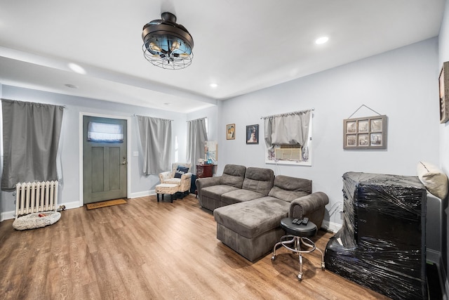 living area with baseboards, recessed lighting, wood finished floors, and radiator